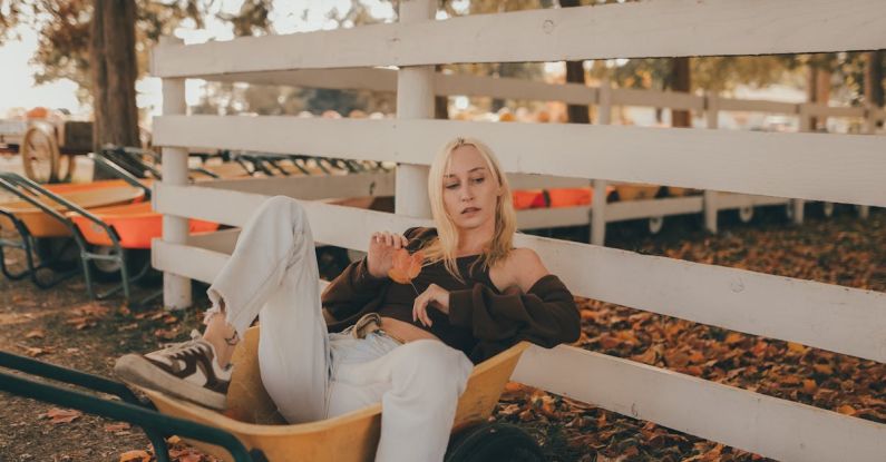 Utility Cart - Young Blonde Woman in White Jeans and Brown Blouse Sitting in a Garden Utility Cart