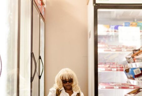 Shelf Risers - A woman sitting in front of a store with a sign that says welcome village